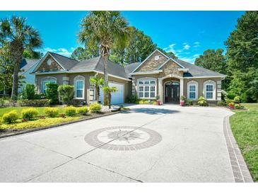 Stately home with stone accents, well-manicured landscaping, and a circular driveway at 5718 Herring Gull Circle, North Myrtle Beach, SC 29582