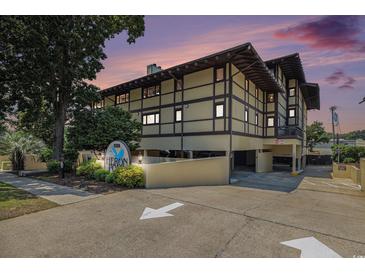 Attractive condo building with unique architecture and professional landscaping during a beautiful sunset at 6813 Porcher Dr. # 1, Myrtle Beach, SC 29572