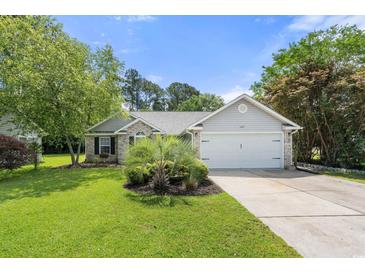 Charming single-story home with brick accents, two car garage, and lush landscaping at 6887 King Arthur Dr., Myrtle Beach, SC 29588