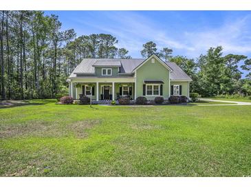 Charming one-story home with a metal roof and a large front yard at 769 Country Club Dr., Pawleys Island, SC 29585