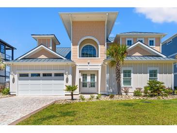 Beautiful beach home featuring a manicured lawn, garage, decorative palms and a charming front entryway at 109 Serenity Point Dr., Little River, SC 29566