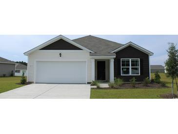 Charming single-story home featuring a two-car garage, manicured lawn, and inviting front entrance at 140 Dagger Ct., Myrtle Beach, SC 29588