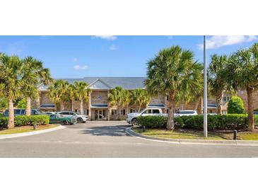 Inviting condo exterior with palm trees, parking, and a well-maintained brick facade under a sunny sky at 210 Double Eagle Dr. # B-2, Surfside Beach, SC 29575