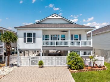 Charming raised beach house with white siding, gray shutters, and a spacious front porch at 2405 Duffy St., North Myrtle Beach, SC 29582