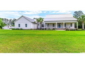 Charming single-story home with a sprawling green lawn and a welcoming front porch with rocking chairs at 3718 Highway 931, Conway, SC 29526
