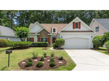 Charming single-Gathering home featuring a stone accent wall, red shutters, well-manicured lawn and two-car garage at 77 Redwing Ct., Pawleys Island, SC 29585