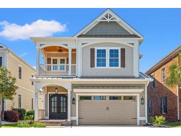 Charming two-story home featuring a front porch, a two car garage, and stylish architectural details at 873 Crystal Water Way, Myrtle Beach, SC 29579