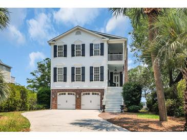 Charming two-story home with brick accents, double garage, and a welcoming staircase leading to a cozy balcony at 92 High Hammock Way, Pawleys Island, SC 29585