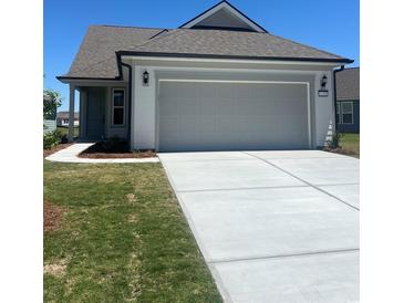 Charming single-story home featuring an attached two-car garage and a well-maintained lawn at 1248 Lady Bird Way, North Myrtle Beach, SC 29582