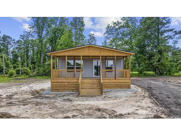 Charming home featuring a covered porch with wooden deck and stairs at 1962 Pint Circle, Longs, SC 29568