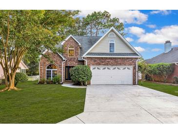 Charming two-story brick home with manicured lawn and attached two-car garage at 2150 North Berwick Dr., Myrtle Beach, SC 29575