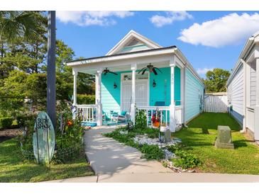 Charming turquoise house with a cozy front porch, ceiling fans, and landscaped garden at 230 Addison Cottage Way, Murrells Inlet, SC 29576