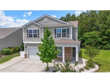Charming two-story home with neutral siding, stone accents, a manicured lawn, and a two-car garage at 278 Carolina Crossing Blvd., Little River, SC 29566