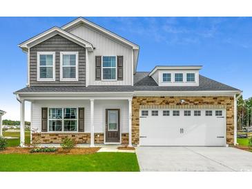 Charming two-story home with a mix of stone and siding, complemented by a well-manicured lawn at 311 Dunlin Pl, Conway, SC 29526