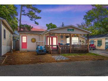 Charming home featuring a cozy front porch, vibrant pink doors, and a fun, welcoming beach vibe at 6001-1643 S Kings Hwy., Myrtle Beach, SC 29575