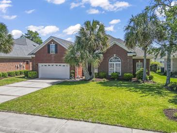 Charming brick home with a well-manicured lawn and mature palm trees at 806 Compass Point Dr., North Myrtle Beach, SC 29582