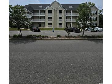 A three-story condo building featuring outdoor patios and a parking lot at 102 Scotch Broom Dr. # B-204, Little River, NC 29566