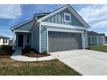 Charming home featuring hardiplank siding, a grey garage door, and a well-manicured lawn at 1232 Lady Bird Way, North Myrtle Beach, SC 29582