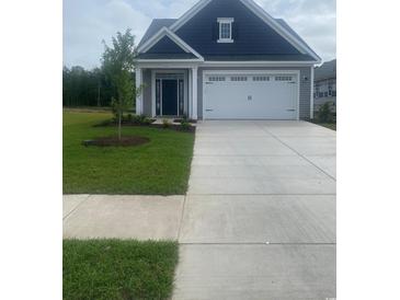 Charming single-story home featuring a manicured lawn, two-car garage and covered porch at 1305 Wykham Park Dr., Myrtle Beach, SC 29579
