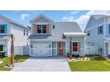 Charming two-story home featuring a single-car garage, light blue siding, and coral window shutters at 1545 Coastal Cove Ln, Calabash, NC 28467