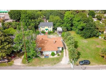 Charming homes nestled among lush greenery, showcasing a serene and picturesque neighborhood setting at 404 13Th Ave. S, Myrtle Beach, SC 29577