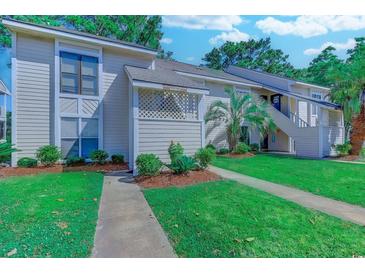 Inviting condo exterior with manicured lawn, showcasing well-maintained landscaping and a pleasant residential setting at 4486 Little River Inn Ln. # 2107, Little River, SC 29566