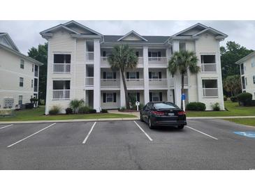 Attractive condo building featuring multi-story units and mature palm trees in a parking lot setting at 477 White River Dr. # 32-H, Myrtle Beach, SC 29579
