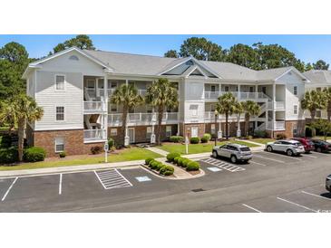 Spacious condo featuring covered balconies, palm trees, brick accents, and ample parking in a convenient location at 6015 Catalina Dr. # 534, North Myrtle Beach, SC 29582