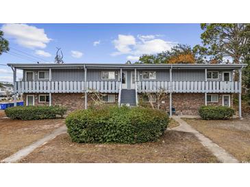 Two-story apartment building with a brick facade and gray siding, surrounded by mature landscaping at 6501 Somerset Dr., Myrtle Beach, SC 29572