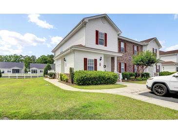 Charming two-story townhome with a manicured lawn and lovely red shutters, perfect for comfortable living at 8855 Radcliff Dr. Nw # 53C, Calabash, NC 28467