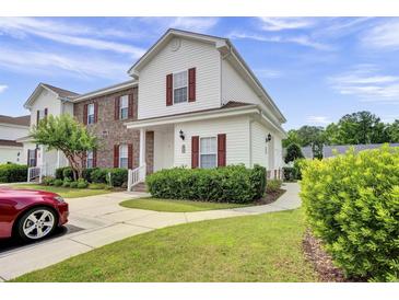 Charming two-story home with red shutters, manicured landscaping, and a concrete walkway at 8855 Radcliff Dr. Nw # 53D, Calabash, NC 28467