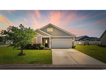 Charming single-Gathering home with well-manicured lawn, two car garage, and grey siding at 924 Sorano St., Myrtle Beach, SC 29579
