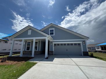 Charming single-story home with a two-car garage, covered porch, and blue siding at 1241 Beeblossom Dr., North Myrtle Beach, SC 29582
