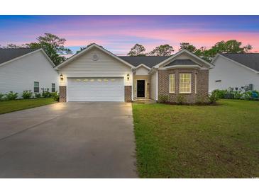 Charming single-story home with a two-car garage and manicured lawn against a twilight sky at 1620 San Andres Ave., Little River, SC 29566