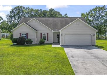 Charming one-story home featuring a well-manicured lawn, attached two-car garage, and inviting front entrance at 176 Whispering Oaks Dr., Longs, SC 29568