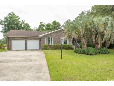 Charming brick home with a well-manicured lawn and mature landscaping at 18 Pine Valley Ln., Surfside Beach, SC 29575