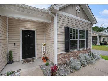 Charming front entrance with black door, welcome sign, and manicured landscaping at 2472 Bayboro St. # C, Loris, SC 29569