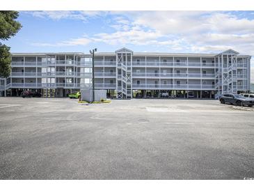 Condominium building exterior featuring a raised structure, parking, and stairwells to access units at 310 Marsh Pl. # 108, Murrells Inlet, SC 29576