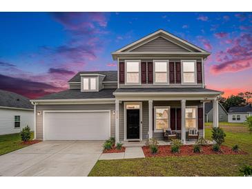 Charming two-story home with gray siding, shutters, a well-manicured lawn, and a welcoming front porch at 3129 Palma Way, Myrtle Beach, SC 29579