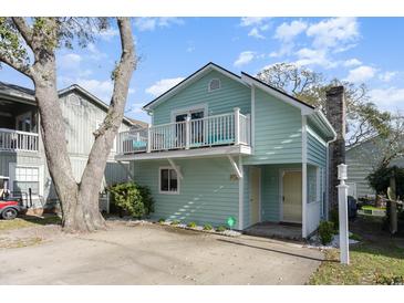 Charming, light blue, two-story home with a cozy front porch and a second-story balcony at 4307 Beverly Ct., North Myrtle Beach, SC 29582
