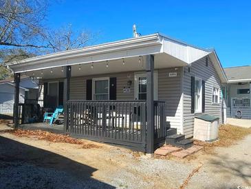 Charming single-story home with a covered porch, dark shutters, and gray siding at 6001 S Kings Hwy., Myrtle Beach, SC 29575