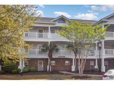 Condo exterior features multiple balconies, brick accents, and well maintained landscaping at 6015 Catalina Dr. # 134, North Myrtle Beach, SC 29582