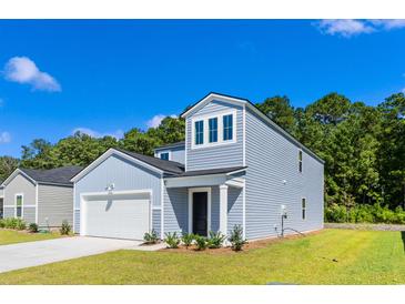 Charming two-story home featuring light blue siding, an attached garage, and a well-manicured lawn at 784 Wapama St., Little River, SC 29566