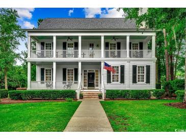 Charming two-story home features a large front porch with white columns and black shutters at 9 Winnowing Way, Pawleys Island, SC 29585