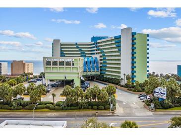 Coral Beach Resort exterior view shows manicured landscaping and parking entrance on a sunny day at 1105 S Ocean Blvd. # 520, Myrtle Beach, SC 29577