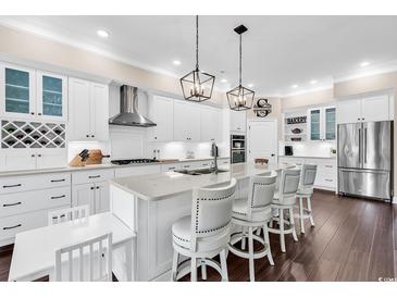 Bright, airy kitchen with white cabinetry, stainless steel appliances, and a spacious center island with seating at 1210 East Isle Of Palms Ave., Myrtle Beach, SC 29579