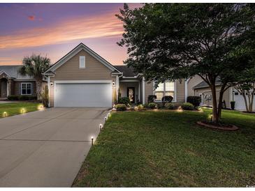 Charming single-story home with a well-manicured lawn, complemented by a large driveway and elegant exterior lighting at 15 Saltwind Loop, Murrells Inlet, SC 29576