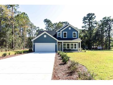 Charming two-story home with blue siding, white trim, and a spacious two-car garage at 155 Mckenzie Circle, Pawleys Island, SC 29585