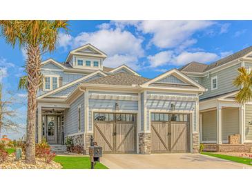 Charming exterior with a two car garage, stone accents, and a well manicured yard with mature landscaping at 201 West Isle Of Palms Ave., Myrtle Beach, SC 29579