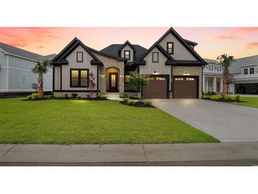 Charming two-story home featuring a landscaped yard, a two-car garage, and stone veneer accents at 2205 Yellow Morel Way, Myrtle Beach, SC 29579